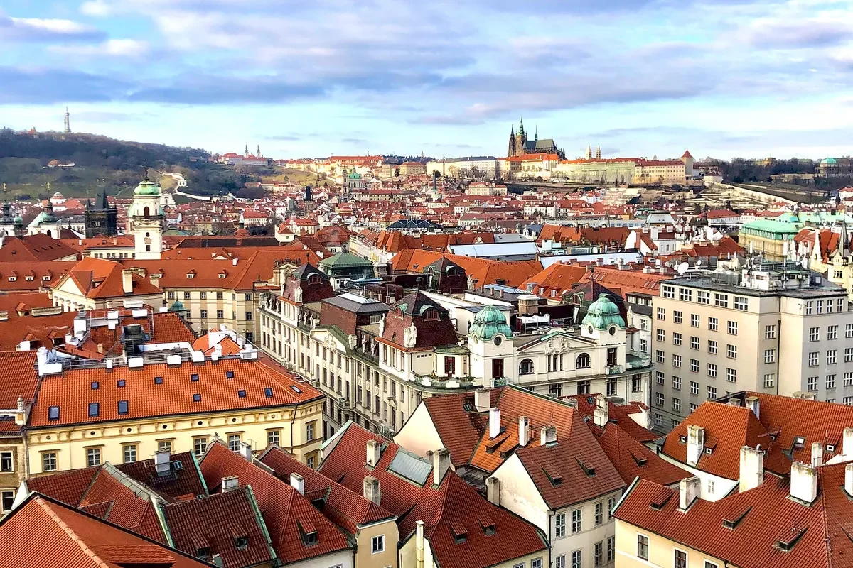 Toàn cảnh mái ngói đỏ khu Phố Cổ Praha nhìn từ tháp Tòa thị chính, xa xa là Lâu đài Praha