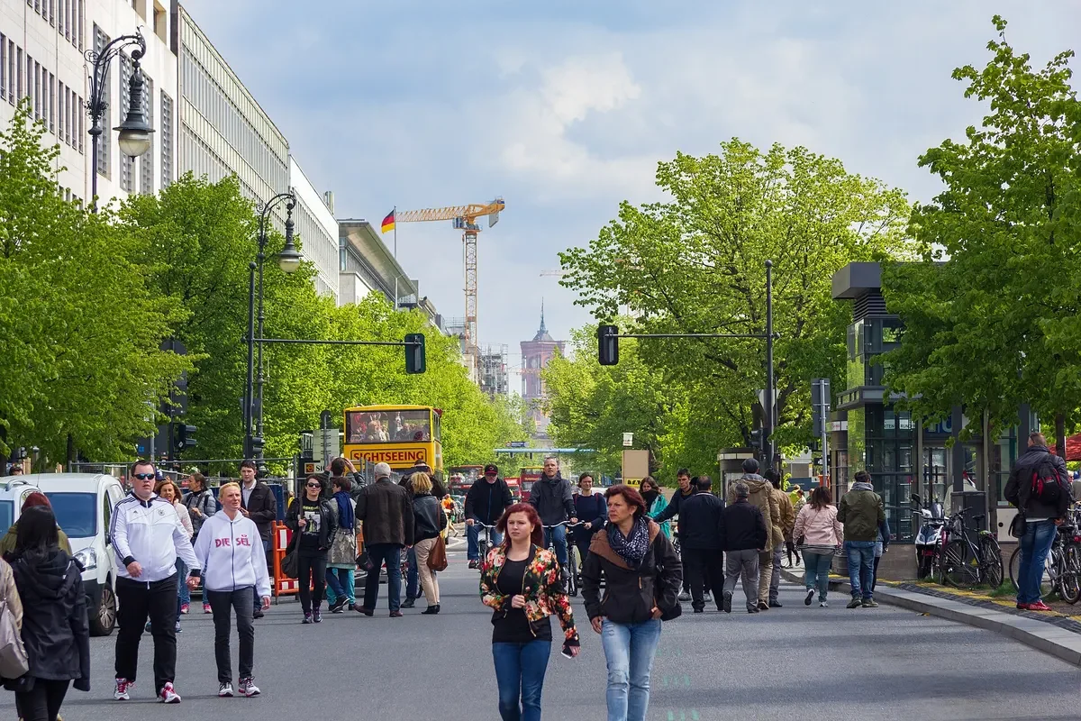Đại lộ Unter den Linden ở Berlin với hàng cây xanh hai bên và người đi bộ trên vỉa hè